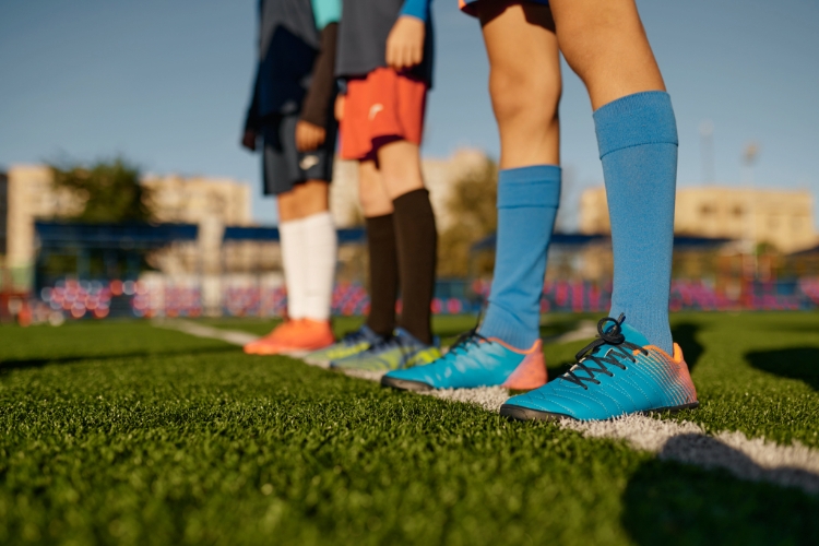 Children ready to play football on artificial grass